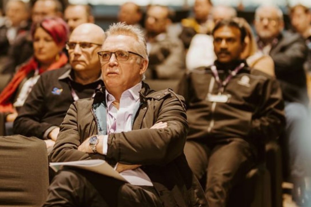 Image of a group of people seated at an expo seminar, focused on the speaker