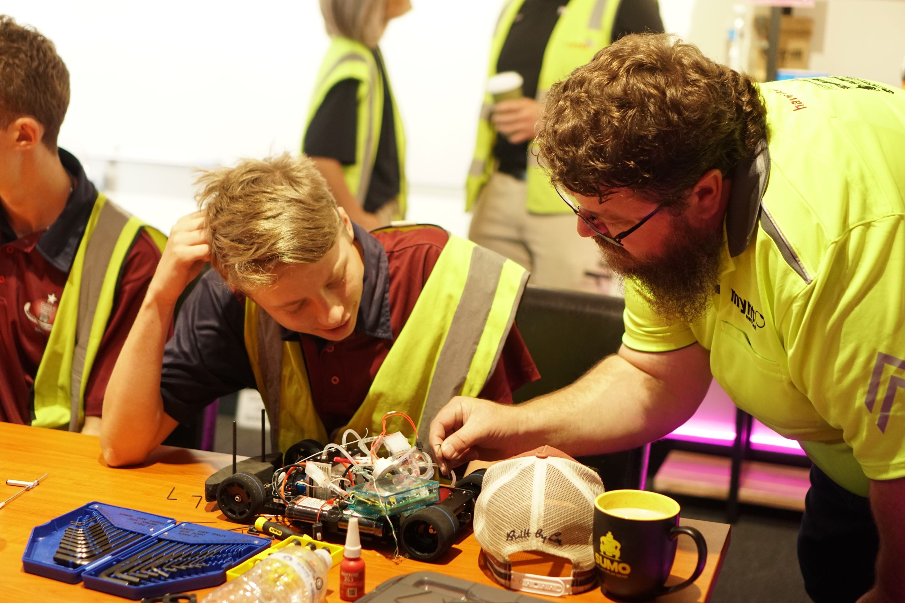 A student reviews his racing car with a hydrogen mentor