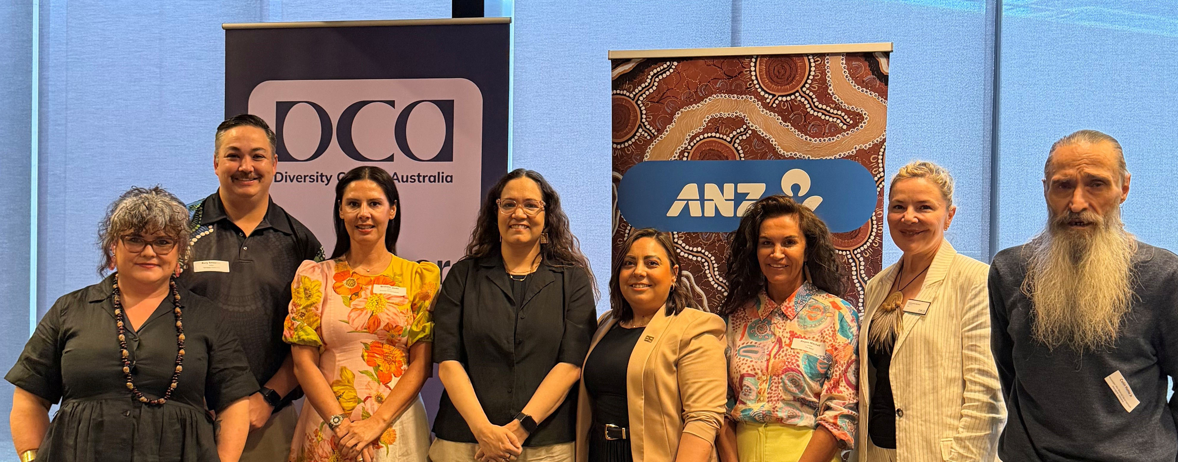 Panelists from Creating Safe and Respectful Workplaces for First Nations Women with Catherine Hunter, Bronwyn Dodd, and Uncle Colin Hunter in front of DCA and ANZ Banner at event