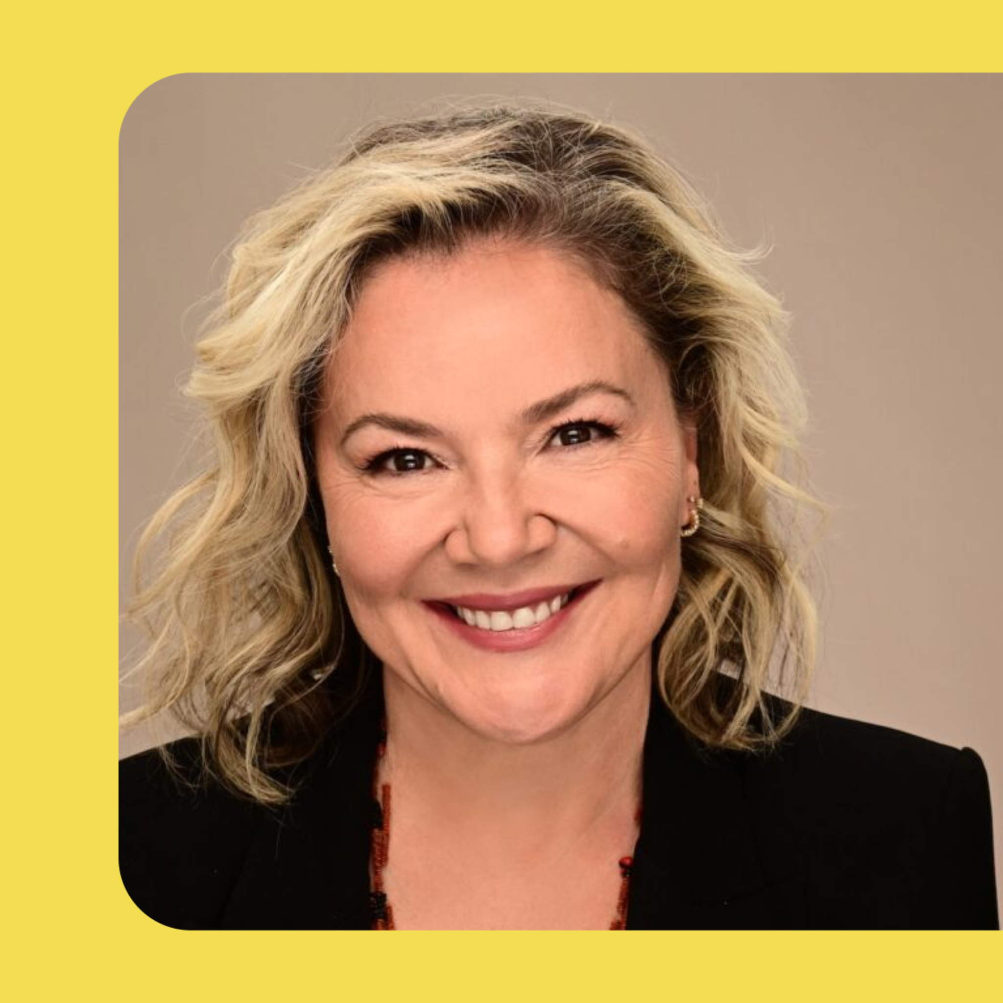 Headshot of Catherine Hunter. Catherine has short, curly, blonde hair and wears a black jacket with a red necklace.