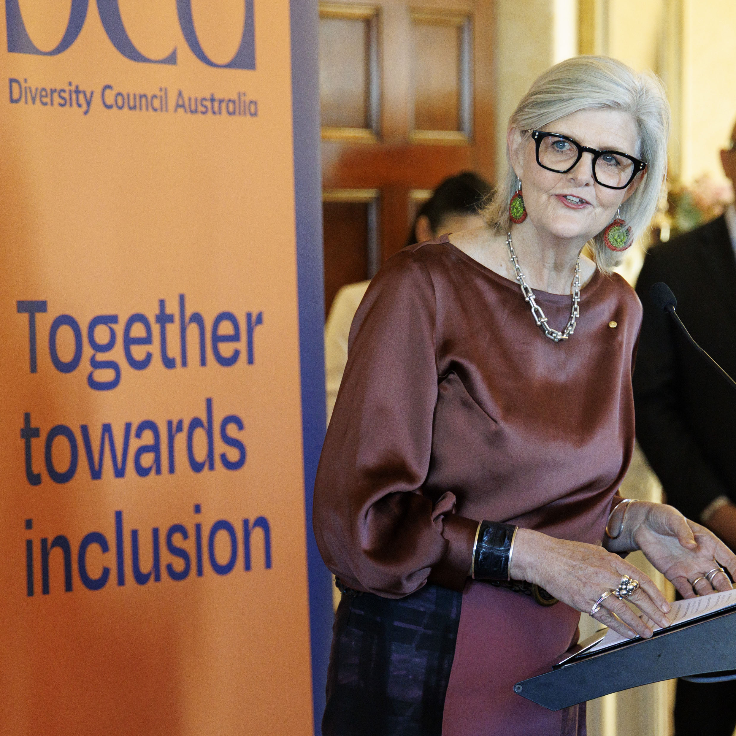 Governor General Sam Mostyn AC standing at the podium at the DCA event smiling