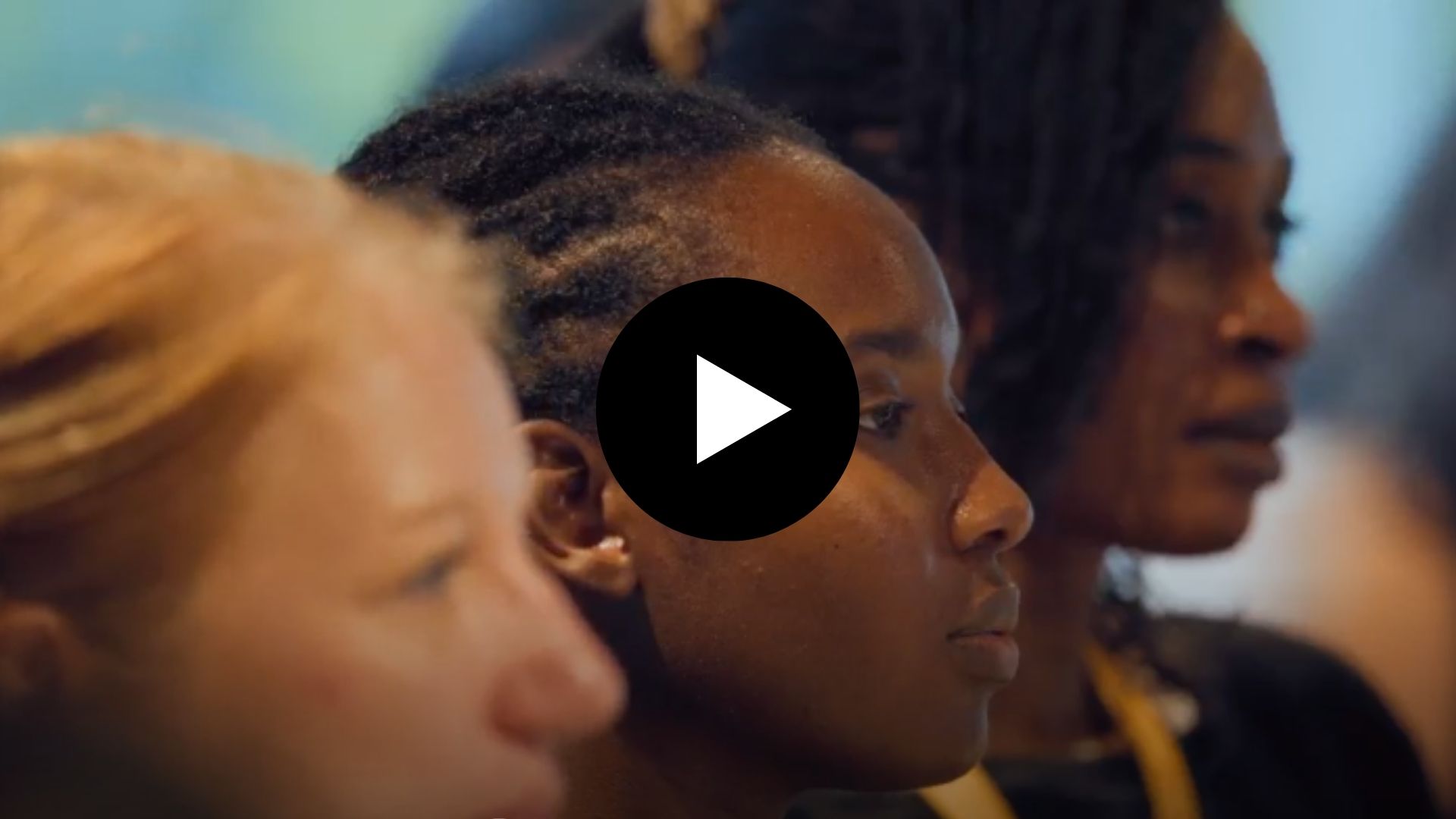Video play button over image of three women's faces in side profile view