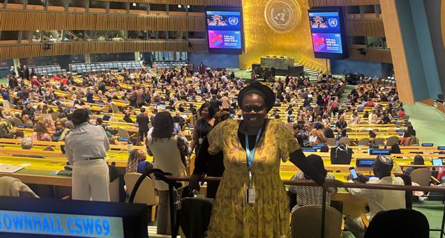 Dr. Virginia Mapedzahama smiling and standing in the hall where CSW69 townhall was held in New York